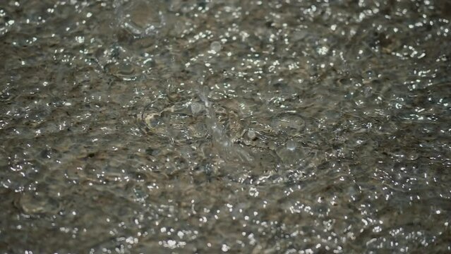 Close-up Clean water. Slow motion water. Slow motion of river , stream flowing through rocks. Mountain river water surface in slow motion. Clear stream making waves in mountain river