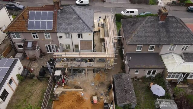 Drone shot of scaffolding on a house undergoing construction work 24p in UK prores