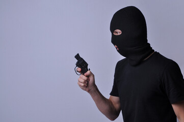 representação de criminoso assaltante segurando arma 