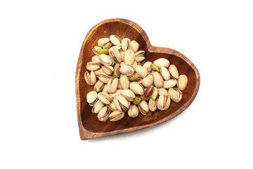 白背景の木製の皿にのせたピスタチオ
