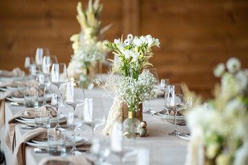 beautiful table setting with flowers and cutlery on wooden table at wedding or dinner. stylish tablewear decorations