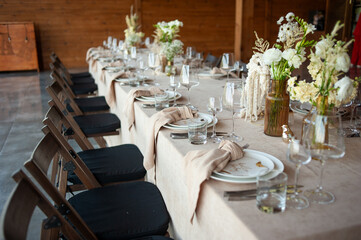 beautiful table setting with flowers and cutlery on wooden table at wedding or dinner. stylish tablewear decorations