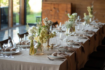 beautiful table setting with flowers and cutlery on wooden table at wedding or dinner. stylish tablewear decorations