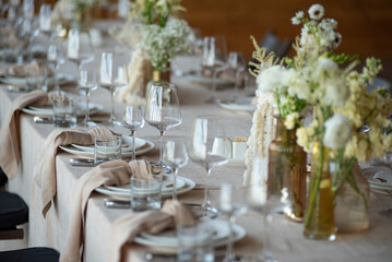 beautiful table setting with flowers and cutlery on wooden table at wedding or dinner. stylish...