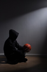 homem atleta triste solitario segurando bola de basquete 