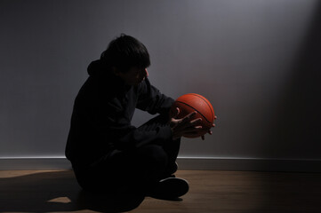 homem atleta triste solitario segurando bola de basquete 