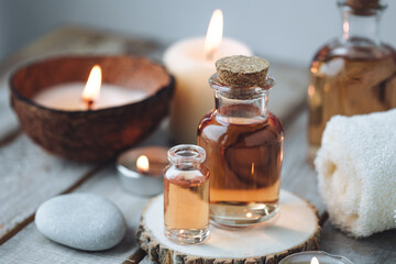 Fototapeta na wymiar Concept of spa treatment in salon with pure organic natural oil. Atmosphere of relax, detention. Aromatherapy, candles, towel, wooden background. Skin care, body gentle treatment