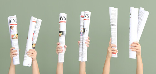 Female hands with newspapers on color background