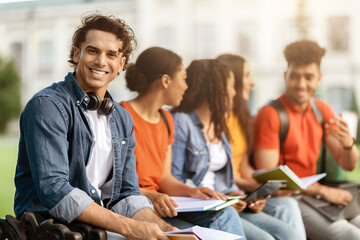 Fototapeta premium Study Together. Student Guy Preparing For Exams Outdoors With His University Friends
