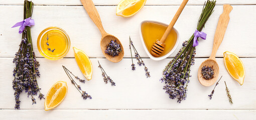 Lavender flowers with lemon pieces and honey on white wooden background