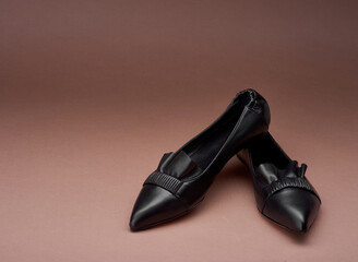 Classy black pointed-toe leather ballet flats with wrinkled and ruffle details isolated on the...