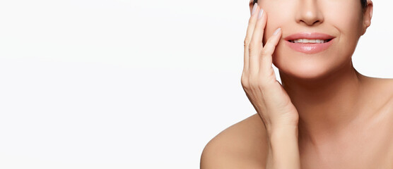 Skincare concept. Middle-aged woman with a beautiful complexion, gently touching her hydrated skin - 624950195