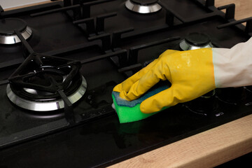 Cleaning the gas stove from dust and dirt. Cleaning a gas stove with kitchen utensils, household...