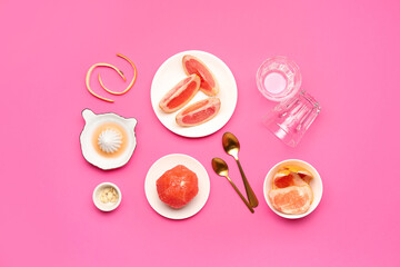 Composition with ripe grapefruits, peel and glasses on pink background