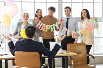 Obraz premium Group of business people greeting their colleague at birthday party in office