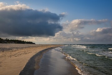 Beautiful holiday landscape by the Polish Baltic Sea. Sandy beach and clouds on a blue background in a holiday concept.