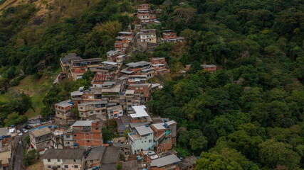 The contrast between the advance of the city with irregular housing on the slopes of the mountains and the Atlantic Forest in the city of Rio de Janeiro.
