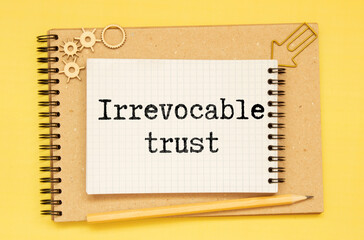 IRREVOCABLE TRUST text on sticker with pen on the black background.