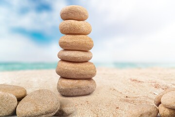 Fototapeta na wymiar Balance stone on the beach sand and sky background
