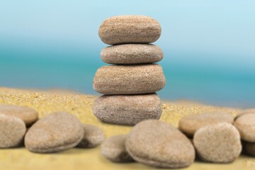Fototapeta na wymiar Balance stone on the beach sand and sky background
