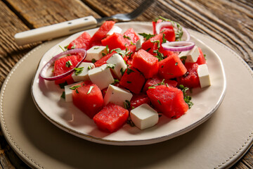 Plate of tasty watermelon salad on wooden background