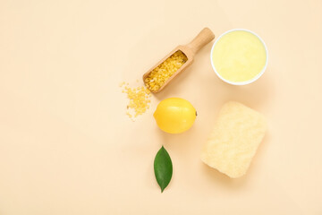 Bowl of lemon body scrub with sea salt and bath sponge on beige background