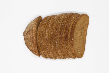 Sliced black bread. Dark rye bread with cumin cut into even pieces on a white background. Wheat black bread on the table. Isolated. Bran from grain. Healthy food. Vegetarian food. Ecological friendly