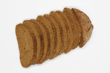 Sliced black bread. Dark rye bread with cumin cut into even pieces on a white background. Wheat black bread on the table. Isolated. Bran from grain. Healthy food. Vegetarian food. Ecological friendly