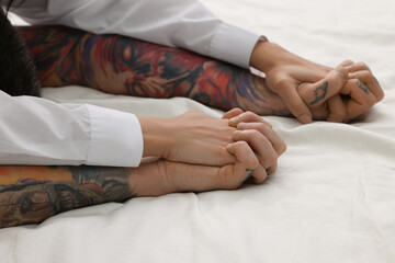 Passionate couple having sex on bed, closeup of hands