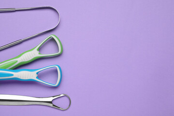 Different tongue cleaners on violet background,flat lay. Space for text