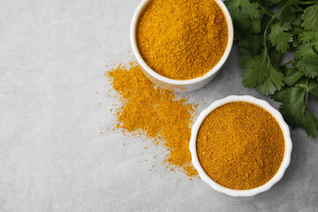 Aromatic curry powder and parsley on light grey table, flat lay. Space for text