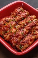 Delicious stuffed cabbage rolls cooked with homemade tomato sauce on table, closeup
