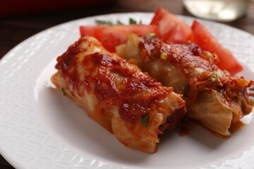 Delicious stuffed cabbage rolls cooked with homemade tomato sauce on plate, closeup