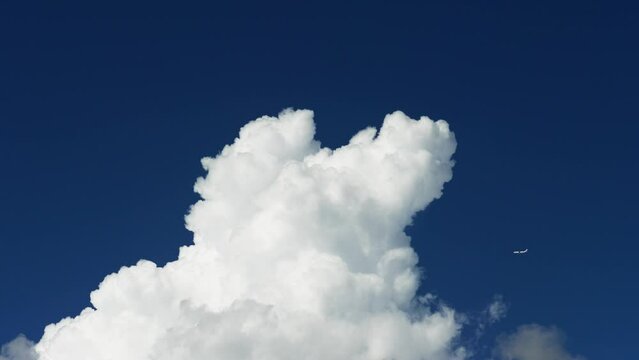 4k footage of airplane fly over white clouds with blue sky in background, real time video.