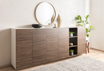 A modern wood dresser stands on a light-wood flooring, with a round mirror hanging on the wall...