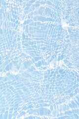 Blue water with ripples on the surface. Defocus blurred transparent blue colored clear calm water surface texture with splashes and bubbles. Water waves with shining pattern texture background.
