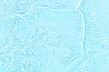 Blue water with ripples on the surface. Defocus blurred transparent blue colored clear calm water surface texture with splashes and bubbles. Water waves with shining pattern texture background.