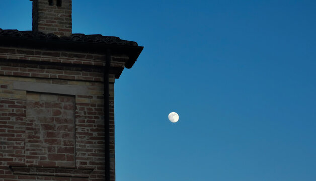 Luna di sera tra le case