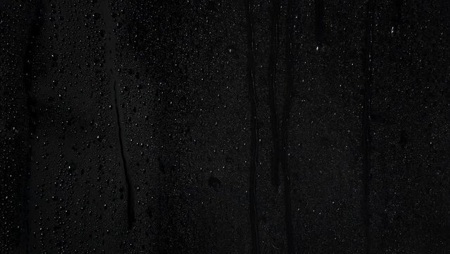 Water drops running on a wet window with light mist