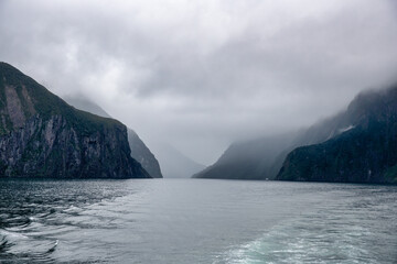 Fototapeta na wymiar Cruising in a large catamaran past Mitre Peak and many waterfalls through the Milford Sound