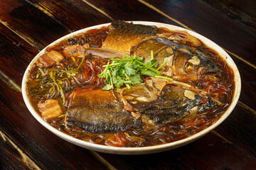 Stewed fish head with vermicelli, a special dish of Northeast China on a wooden background