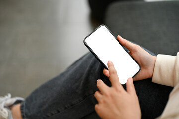 A woman using her smartphone while relaxing in a cafe. smartphone white screen mockup