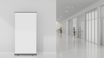An empty mockup poster stands on the floor in a building hallway or corridor area