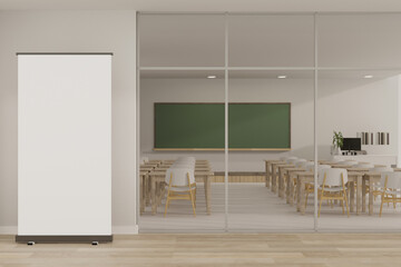 An empty mockup poster stand on the floor in front of a contemporary minimalist classroom.