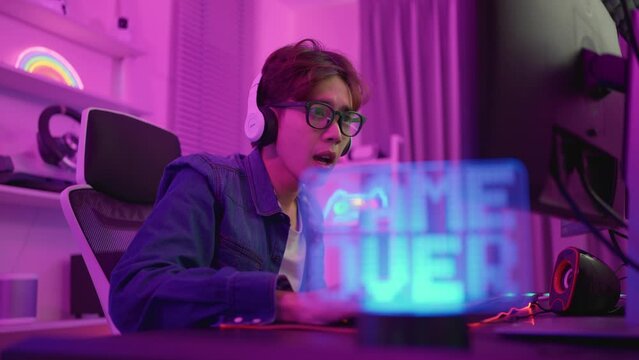 Asian e-sport man loser gamer playing online video game on computer. 