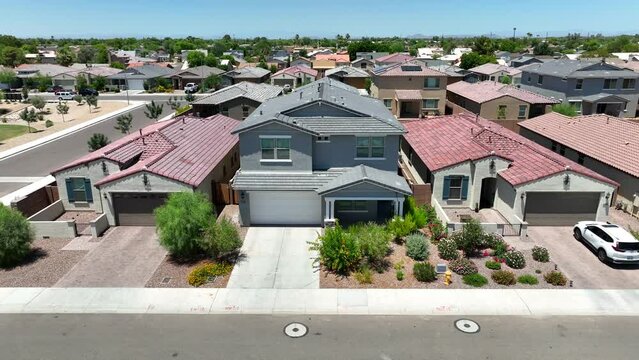 Stucco house in new housing development in Southwest USA. American neighborhood. Aerial push in on upscale home with desert landscaping, Xeriscaping.