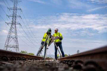 Surveyor engineers team wearing safety uniform,helmet and blueprint document checking inspection by...