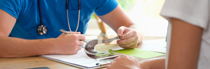 Doctor diagnoses patient by looking at ultrasound results.
