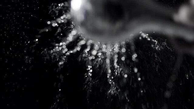 Water from as hower head spray on window with beautiful bokeh streaming splashes 