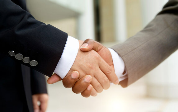African businessman's hand shaking white businessman's hand  making a  deal